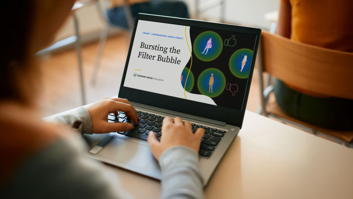 We see over the shoulder of a student looking at a laptop screen featuring a lesson on filter bubbles.