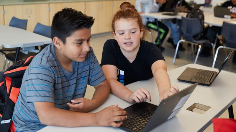 two high school students on chromebooks