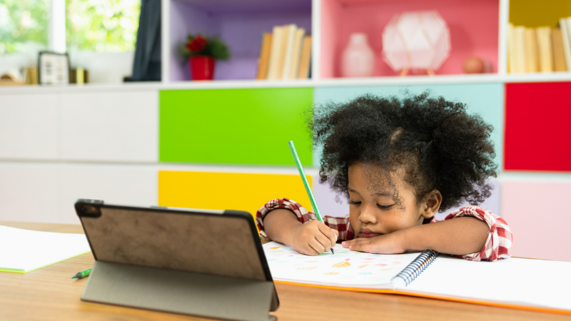 young african american girl drawing while looking at tablet young african american girl drawing while looking at tablet