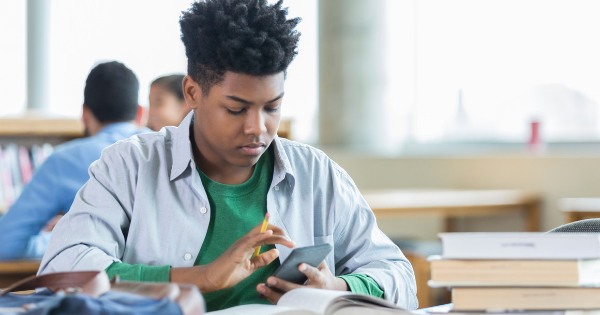 teen on cellphone in the classroom teen on cellphone in the classroom