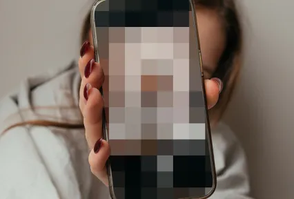 Child holding phone with pixelated screen